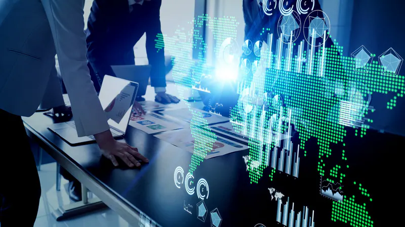 Businesspeople working around a laptop with a luminous world map and data charts