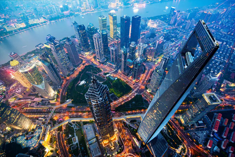 Aerial view of illuminated skyscrapers and a river at blue hour